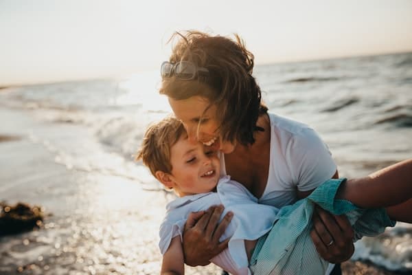 A parent holding their child in the golden hour